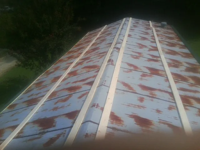 Rusted metal roof panels with new wood purlins before replacement — Storm Damage Roof Repair in Blount by Roofing Brothers