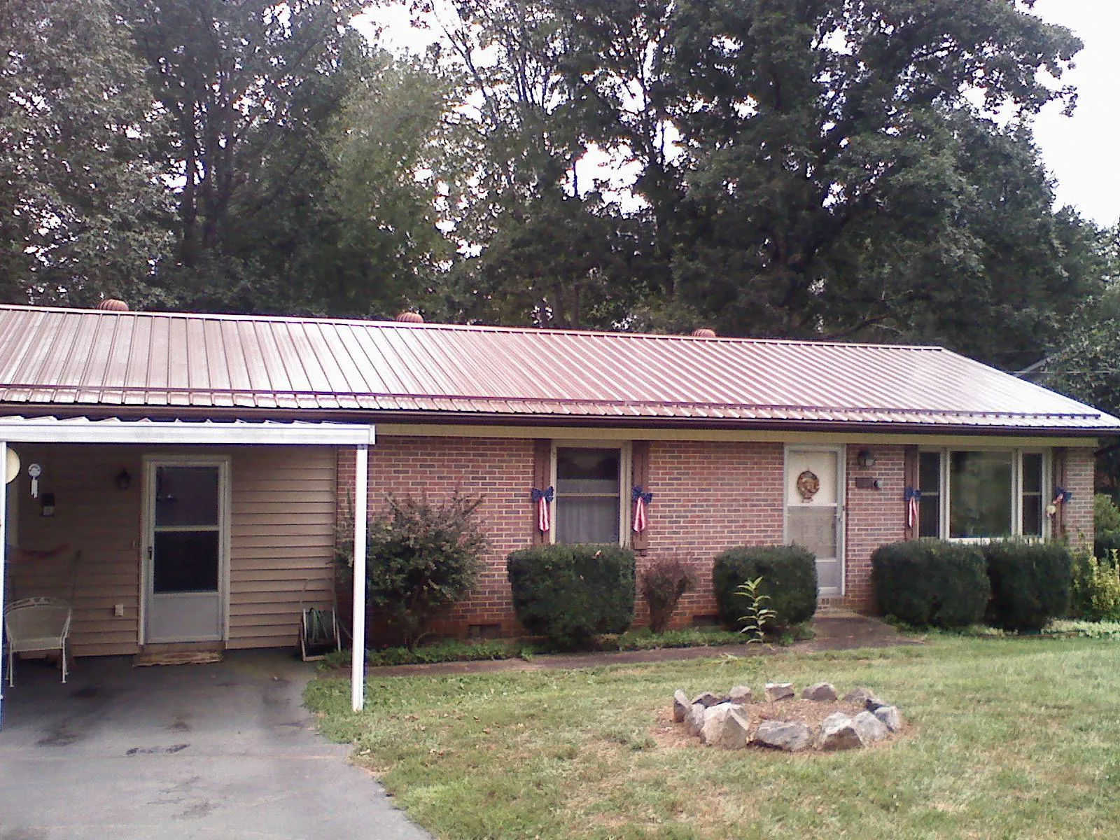Bronze metal roof and carport on a brick ranch home — Roof Repair work by our crew in Blount
